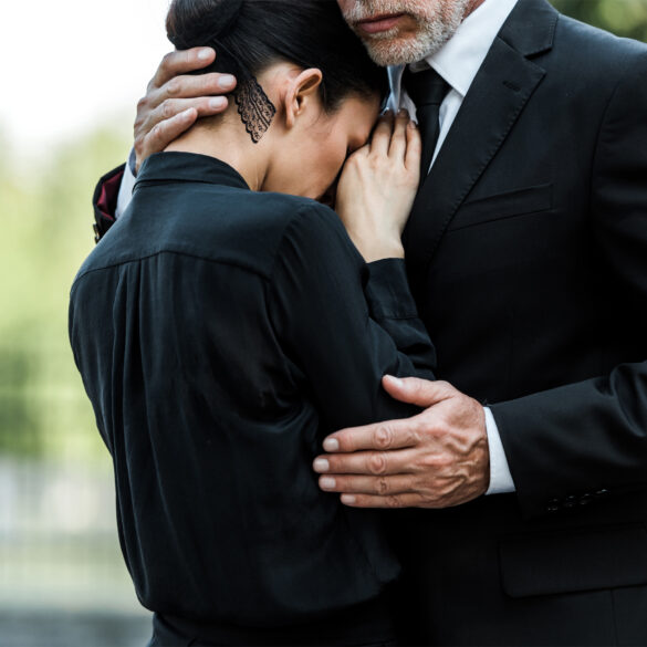 Image of man consoling woman at funeral.